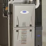 Gray metallic furnace with visible vents and blue light indicator, showcasing AirLux Heating & Cooling services.