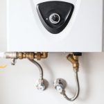 Water heater unit with dial control, pipes, and valves for efficient boiler maintenance and winter preparation.