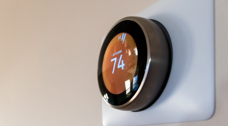 Smart thermostat displaying temperature settings, relevant to energy management and HVAC efficiency.